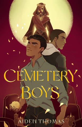 The book cover for Cemetery Boys by Aidan Thomas is maroon with a moon in the background above tombstones and candles. The title is in gold and all caps. There are two brown-skinned young people on the cover and one ethereal being with an exposed skull in floating behind them, backlit by the moon. Marigold petals, almost transluscent, float through the air coming from a glowing flower in the one of the teen's hands toward the floating figure in the background.